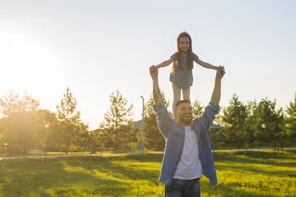 Heureux père homme tenant sa petite fille sur le cou dans le parc d'été — Photo