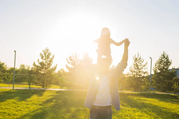 Heureux père homme tenant sa petite fille sur le cou dans le parc d'été — Photo