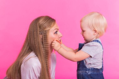 Tuhaf ailenin pembe bir arka plan üzerinde. Anne ve kızı kızı. Anne ve çocuk eğleniyor musun.