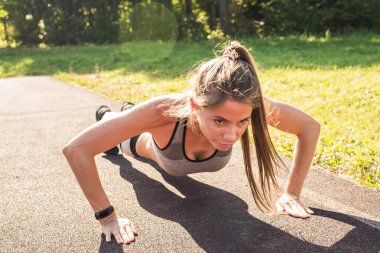 Uygun kadın parkta şınav.