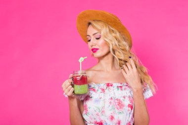 Pembe bir arka plan üzerinde yeşil güler yüzlü genç güzel kadın