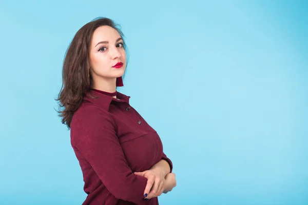 Portrét vážné příležitostné bruneta kavkazské podnikatelka na sobě stojící na modrém podkladu s kopií prostor — Stock fotografie