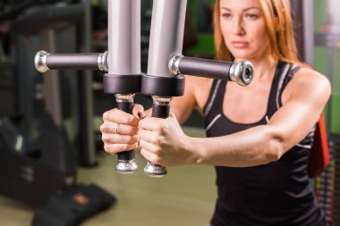 kadın fitness eğitimi bir spor salonunda ağırlık bir kelebek makinede