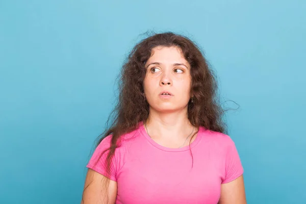 Close up retrato de uma bela jovem com cabelo encaracolado no fundo azul — Fotografia de Stock