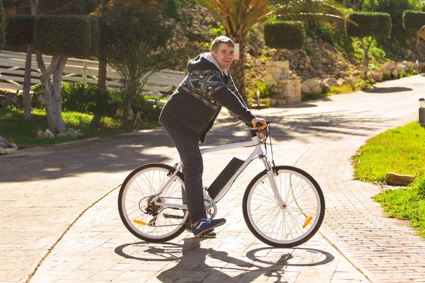 Knappe jongeman met fiets in park op zonnige dag — Stockfoto