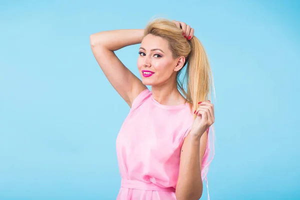 Mulher bonita com longos cabelos loiros lisos. Modelo de moda posando no estúdio em fundo azul — Fotografia de Stock