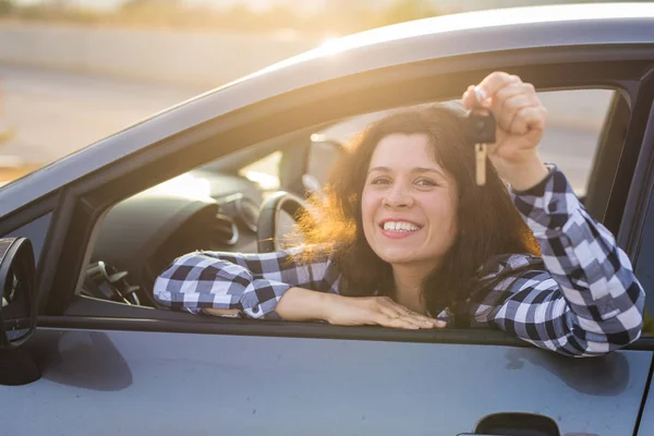 Junge Frau Testfahrt neues Auto und zeigt Schlüssel. Autokauf oder Mietkonzept — Stockfoto
