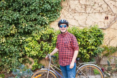 ayakta adam ve Onun Bisiklet yeşil tutun