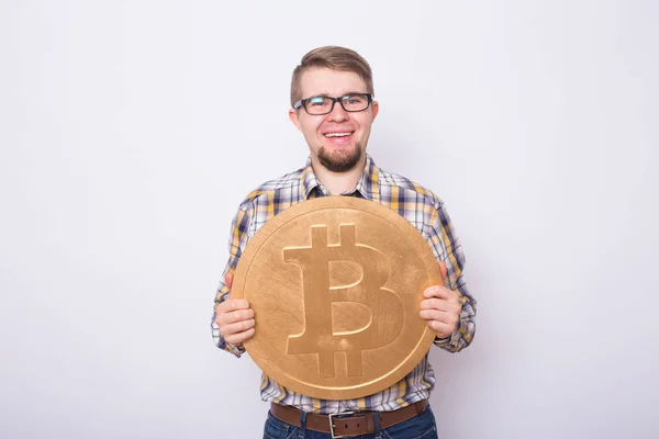Hombre alegre celebración de oro bitcoin - criptomoneda popular, dinero virtual — Foto de Stock