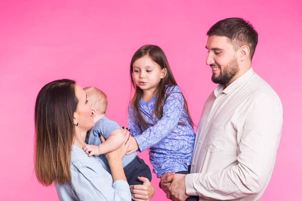 Glücklich gemischte Rasse Familienporträt lächelnd auf rosa Hintergrund — Stockfoto