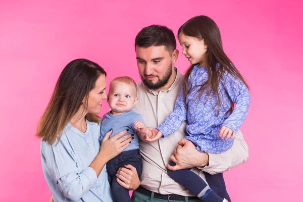 Retrato de la joven familia de raza mixta feliz sobre fondo rosa . — Foto de Stock