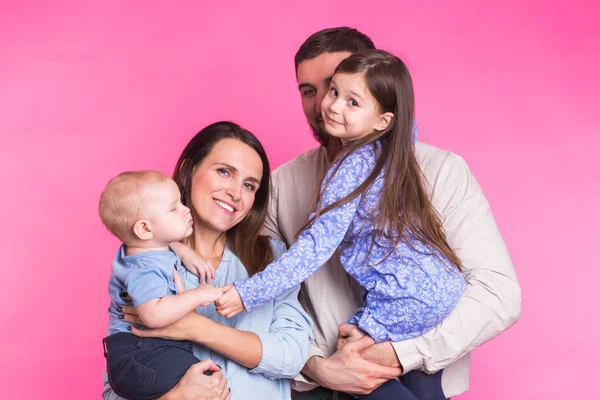 Retrato de la joven familia de raza mixta feliz sobre fondo rosa . — Foto de Stock