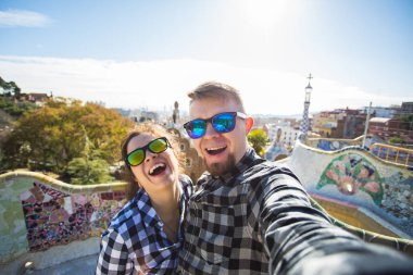 Çift selfie portre ile smartphone Park Guell, Barselona, İspanya, yapım mutlu seyahat. Güzel genç çift kamera ile akıllı telefon aşık gülümseyen fotoğrafı çekmek