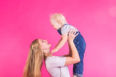 mutlu küçük kız ve annesi pembe arka plan üzerinde eğleniyor