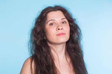Mavi arka plan yakın çekim kıvırcık saçlı kadın.
