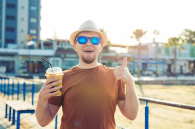yaşam tarzı, içecekler ve insanlar kavramı - kahve frappe tek kullanımlık kağıt Kupası açık havada içme güneş gözlüklü adam