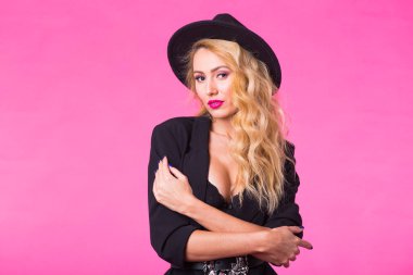 Stil, insanlar ve lüks konsepti - siyah şapka giyen güzel beyaz kadın. Moda stüdyo portre pembe bir arka plan üzerinde