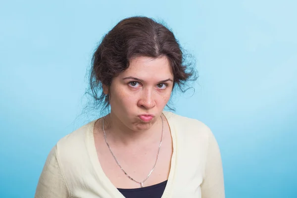 Portrait de jeune femme en colère sur fond bleu — Photo