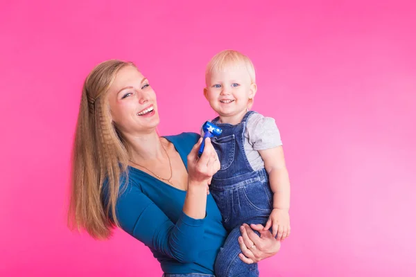 Joven madre e hija divirtiéndose juntas sobre fondo rosa — Foto de Stock