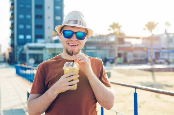 Estilo de vida, las bebidas y el concepto de la gente - hombre en gafas de sol beber frappe café de la taza de papel desechable al aire libre — Foto de Stock
