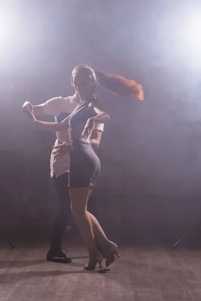 Pareja joven bailando baile latino Bachata, merengue, salsa. Dos poses de elegancia en clase de baile — Foto de Stock