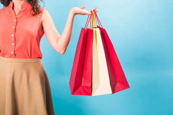 Primer plano de la mujer sosteniendo bolsas, aislado sobre fondo de estudio azul — Foto de Stock