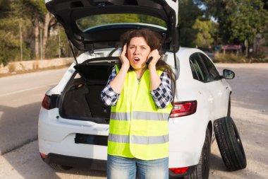 Kırık aşağı araba. Onu acil durum yardım için bekleyen yolda araba aşağı kırık yanında duran kadın