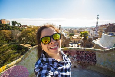 Genç mutlu kadın selfie portre ile smartphone Park Guell, Barselona, İspanya, yapma. Kamera çekimi fotoğraf akıllı telefon gülümseyen ile güzel kız