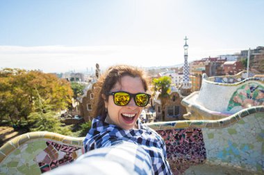 Genç mutlu kadın selfie portre ile smartphone Park Guell, Barselona, İspanya, yapma. Kamera çekimi fotoğraf akıllı telefon gülümseyen ile güzel kız