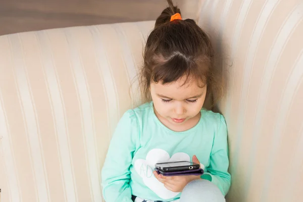 Mała dziewczynka dziecko grać na smartfonie w domu — Zdjęcie stockowe