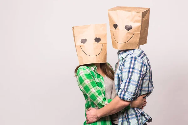 爱情情侣用纸袋遮住脸上的白色背景 — 图库照片