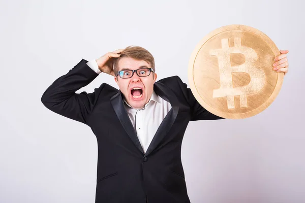 Retrato de un hombre de negocios gritando tiene un gran bitcoin de oro en sus brazos. Hombre en pánico de accidente criptomoneda — Foto de Stock