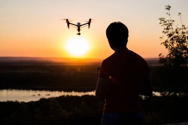 silhouette of drone, quadrocopter with photo camera flying in the sky.