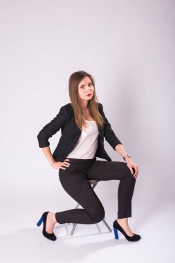 Studio, beyaz arka plan üzerinde izole resmi takım elbise poz esmer saçlı beyaz çekici kadın modeli