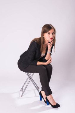 bir sandalye beyaz arka planda siyah elbiseli güzel genç iş kadını oturur