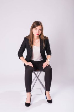 Beyaz arka plan üzerinde sandalye üzerinde oturan güzel cinsel işkadını.