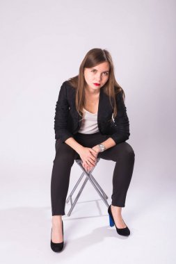 Beyaz arka plan üzerinde sandalye üzerinde oturan güzel cinsel işkadını.