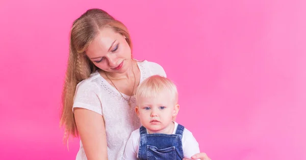 Feliz niña y su madre divirtiéndose sobre fondo rosa — Foto de Stock