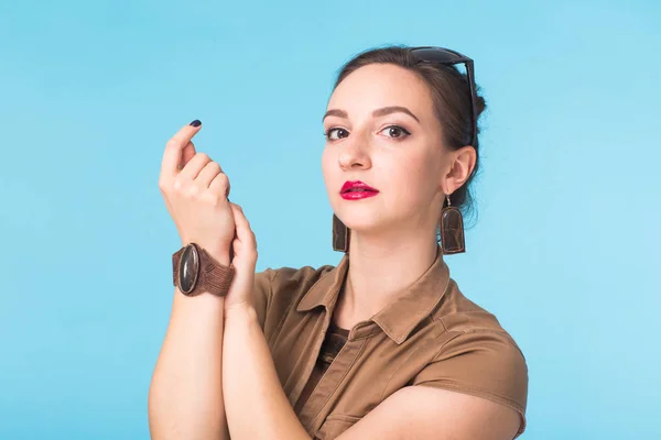 Retrato feminino de moda de beleza. Sorrindo jovem mulher no fundo da parede azul . — Fotografia de Stock