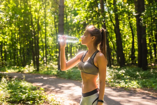 Jeune femme buvant de l'eau après avoir couru dehors — Photo