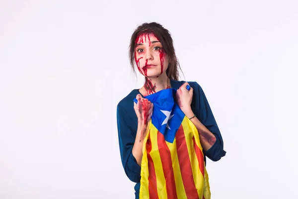 The victim woman holds the flag of Catalonia on white background with copyspace . Protest against terrorism.