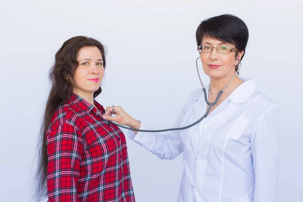 Médico ouvindo o peito dos pacientes com estetoscópio sobre fundo branco — Fotografia de Stock