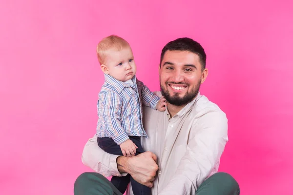 Baby in Papas Händen. rosa Hintergrund. — Stockfoto