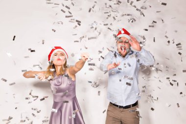 Yeni yıl, Noel ve parti konsepti - Neşeli gençler beyaz arka planda konfeti yağmuruna tutuldu.