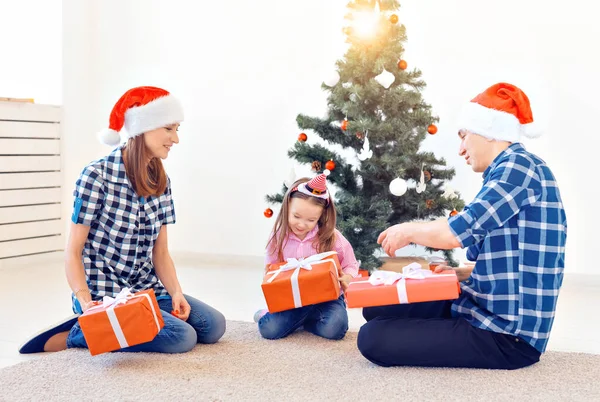Vacaciones y presenta el concepto - Retrato de una familia feliz regalos de apertura en época de Navidad — Foto de Stock
