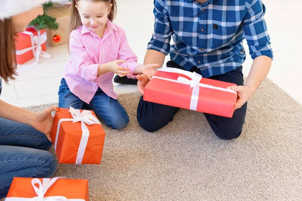 Vacaciones y presenta el concepto - Primer plano de los regalos de apertura de la familia en Navidad — Foto de Stock