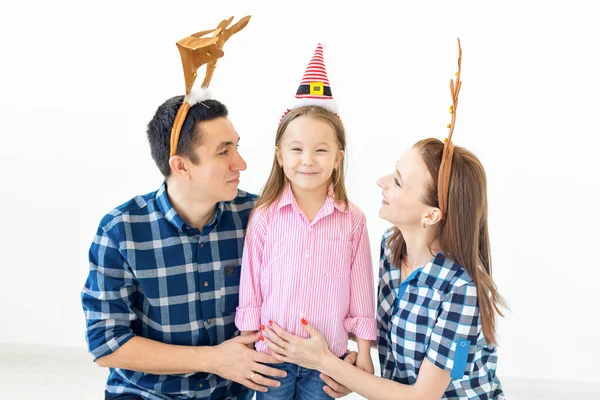 Concepto de vacaciones de invierno: familia navideña con cuernos de Santa Sombrero y ciervo. Celebración familiar sonriente — Foto de Stock