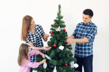 Tatiller, Noel ve kutlama konsepti - Mutlu aile Noel ağacı beyaz arka planda tatilde süslenir