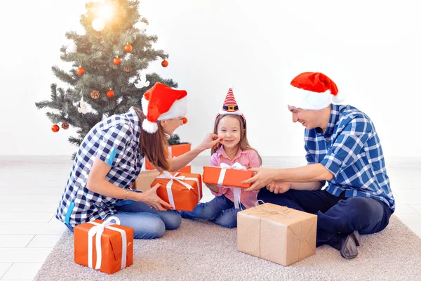 X-mas e concetto di vacanza - Natale di apertura della famiglia presente di fronte all'albero — Foto Stock