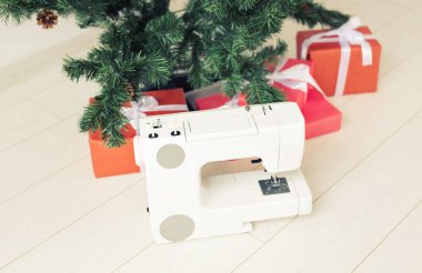 Tatiller, kıyafet tasarımı ve hediye konsepti - Noel ağacı altında dikiş makinesi